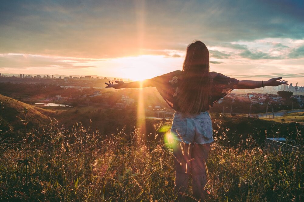 teen spreading arms in field after conquering anxiety