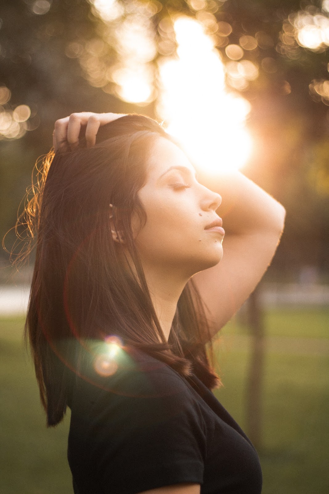 woman in sunlight breathing with eyes closed