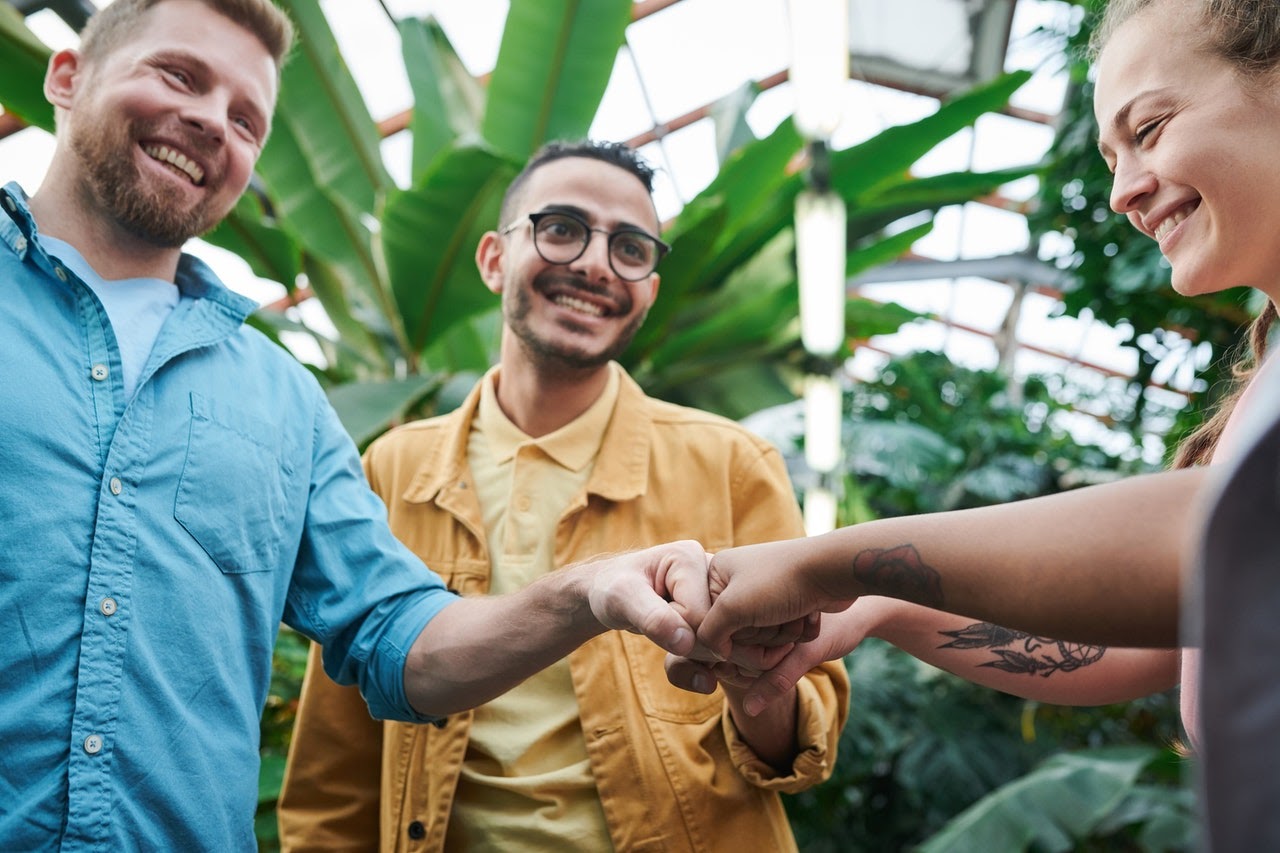 friends fist bumping in greenhouse