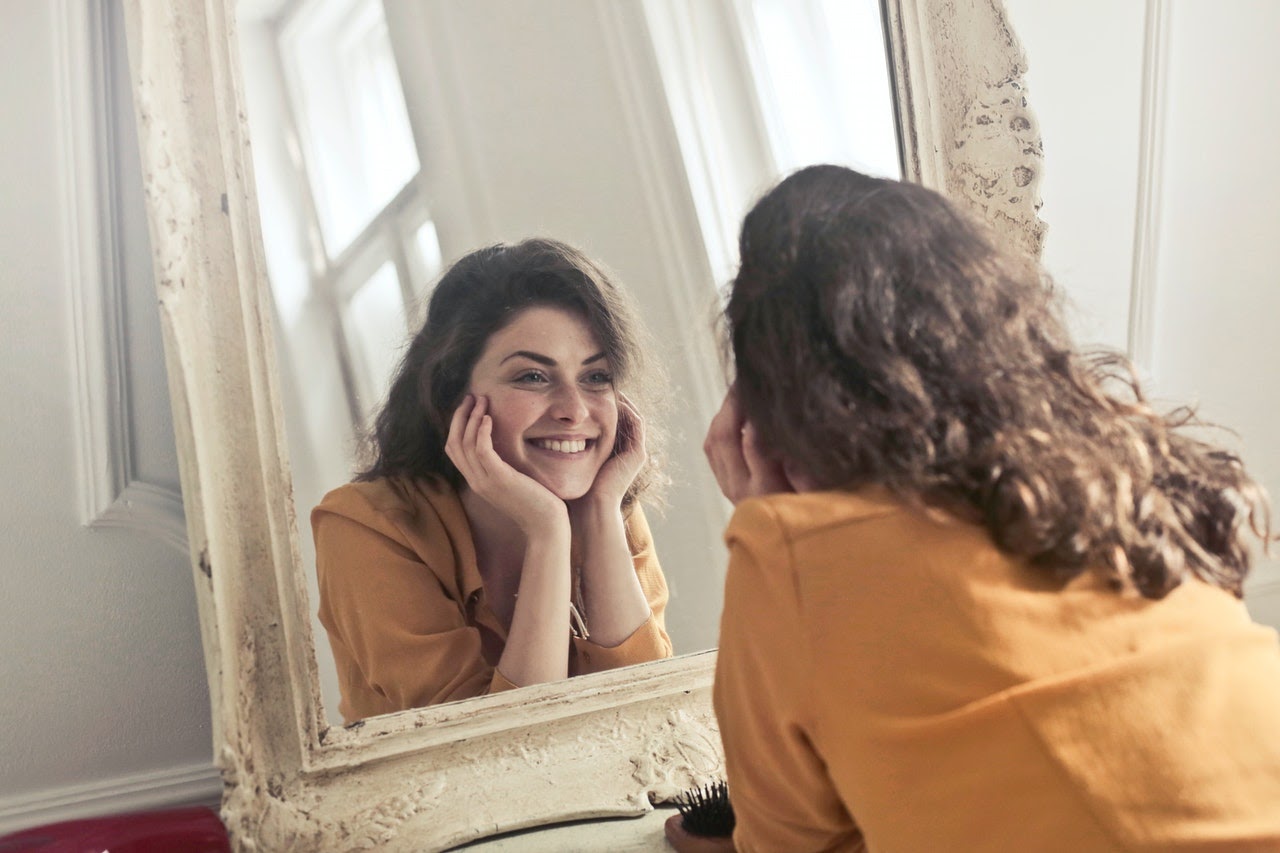 woman looking in mirror smiling