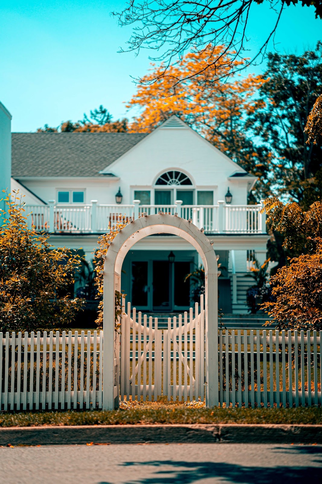 orange and teel house with clean white fence