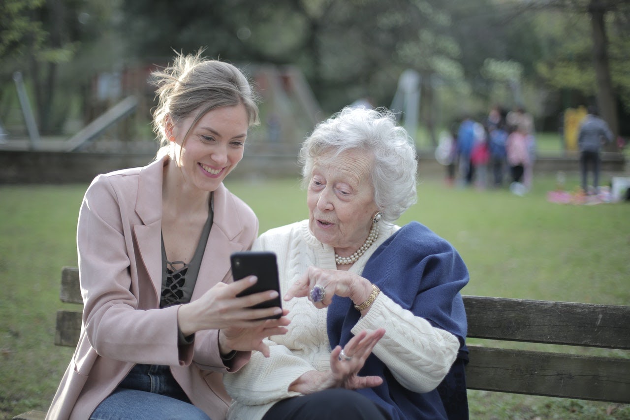 women showing phone to elder