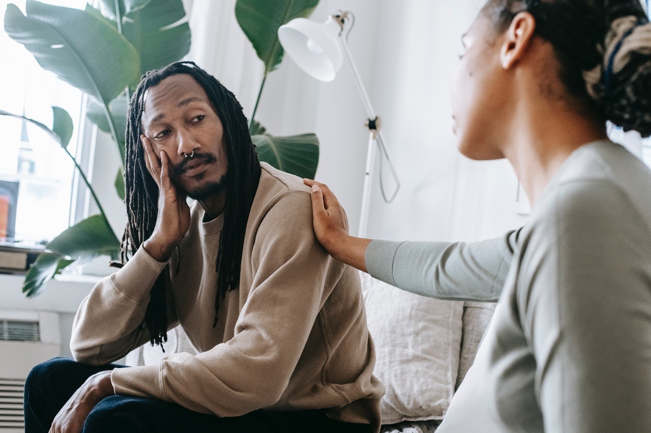 Man and woman having a conversation on the couch.