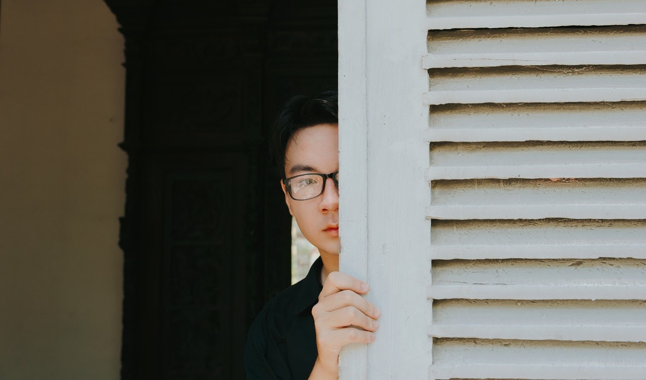 Man hiding behind a door. 