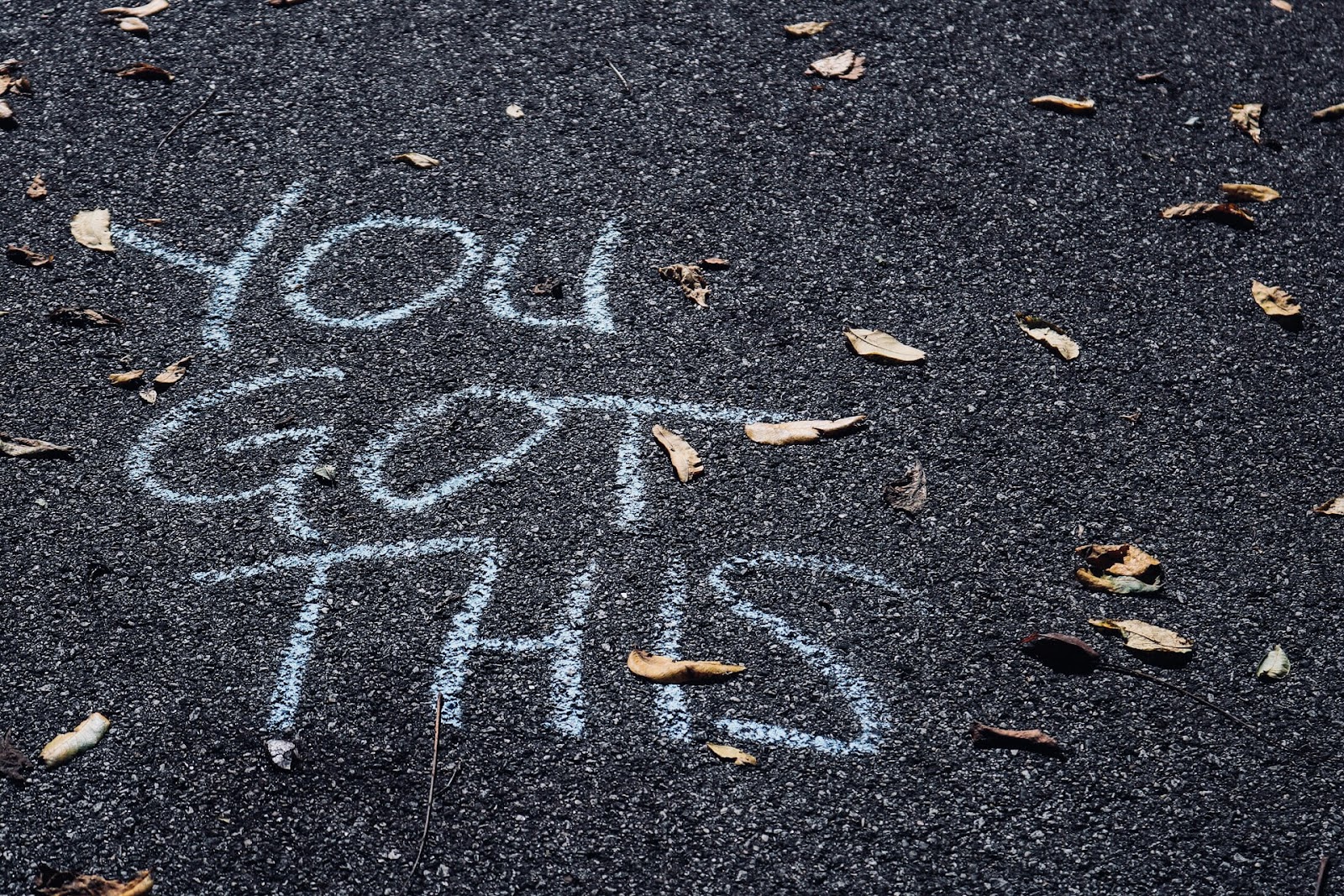 "You've Got This" text in chalk on black driveway pavement. 