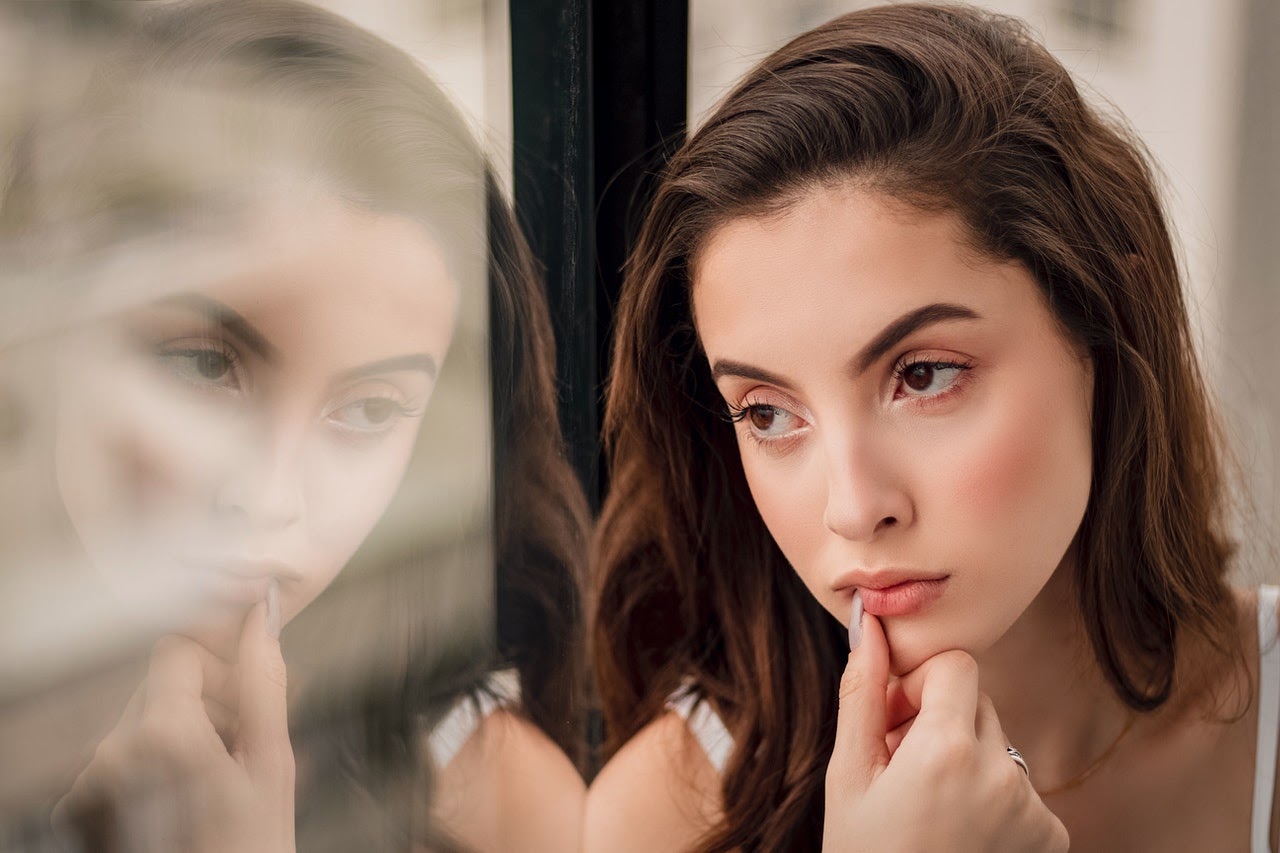 Woman self reflecting in a window.