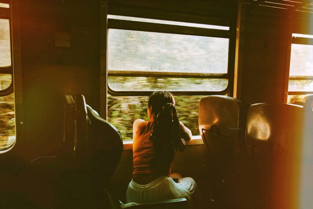 Woman who suffers from post-holiday depression looking out of a moving train window.