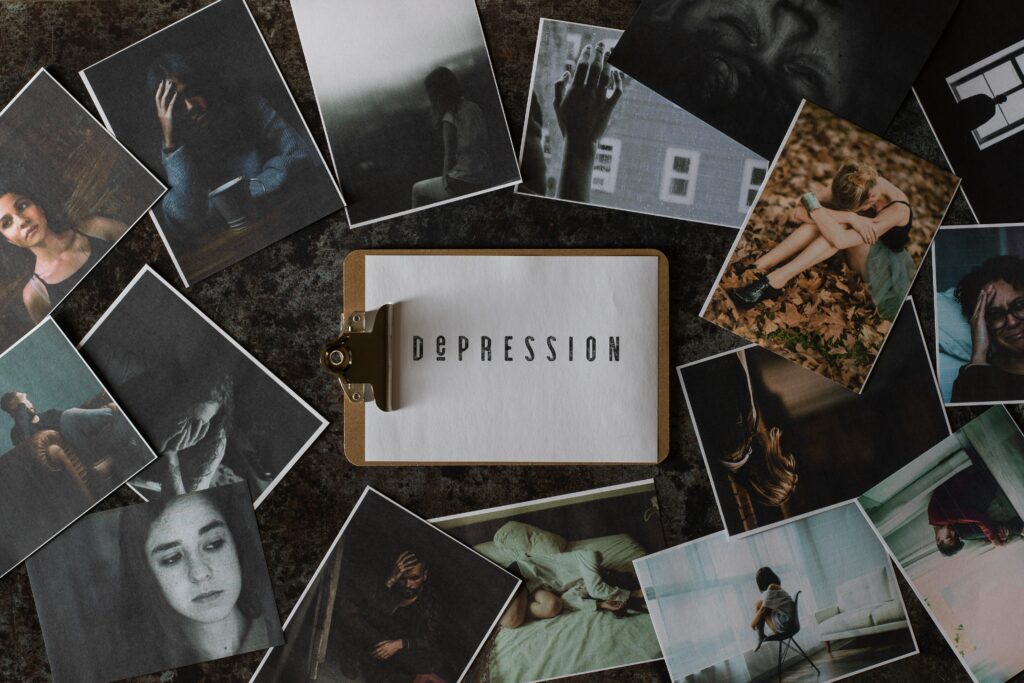 "Depression" written on paper surrounded by dark moody photos.